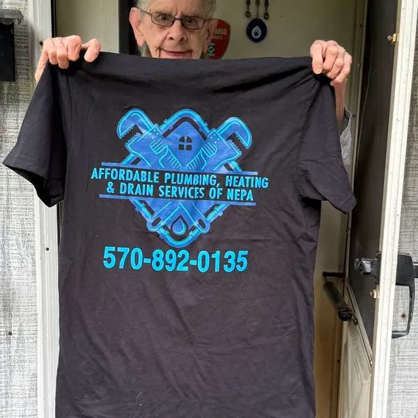 Dolores, a 91-year-old Affordable Plumbing NEPA customer in Archbald PA, holding her company T-shirt